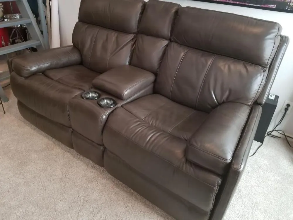 Dark brown reclining loveseat with center console after repair