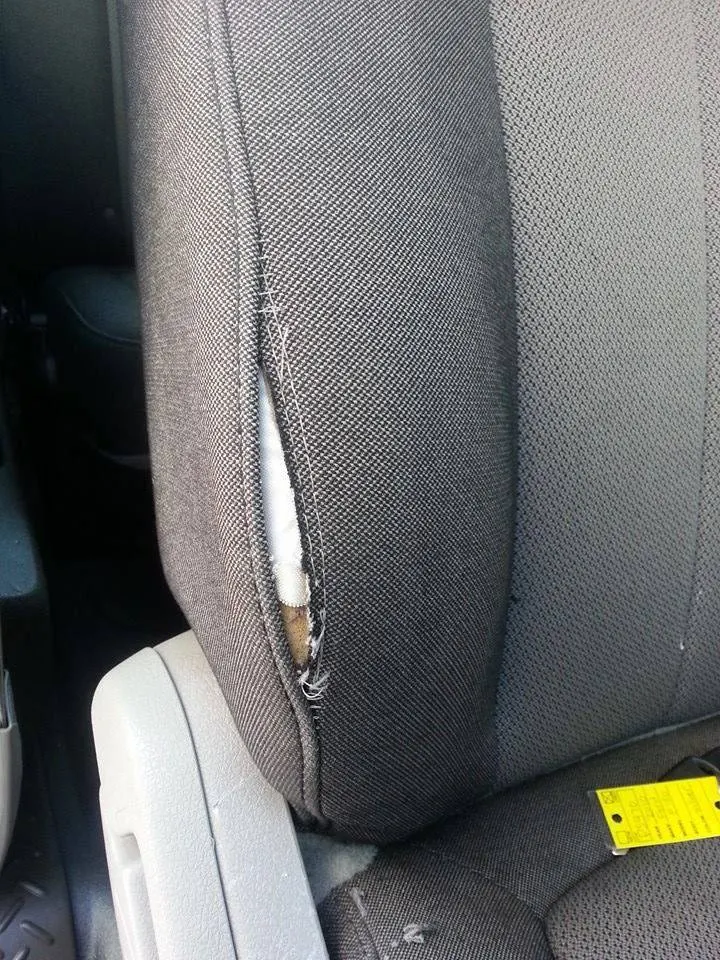 Torn stitched leather seat bolster before upholstery repair